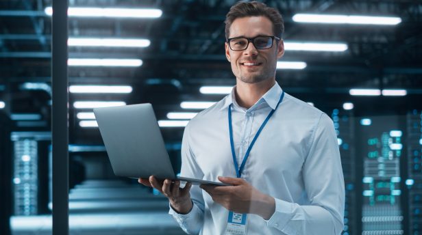 A security specialist with a laptop in a data centre